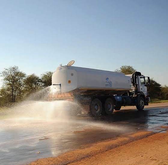 Water bowser truck spraying water on a road