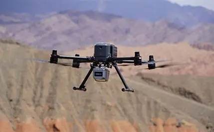 Survey drone flying over mountainous terrain.