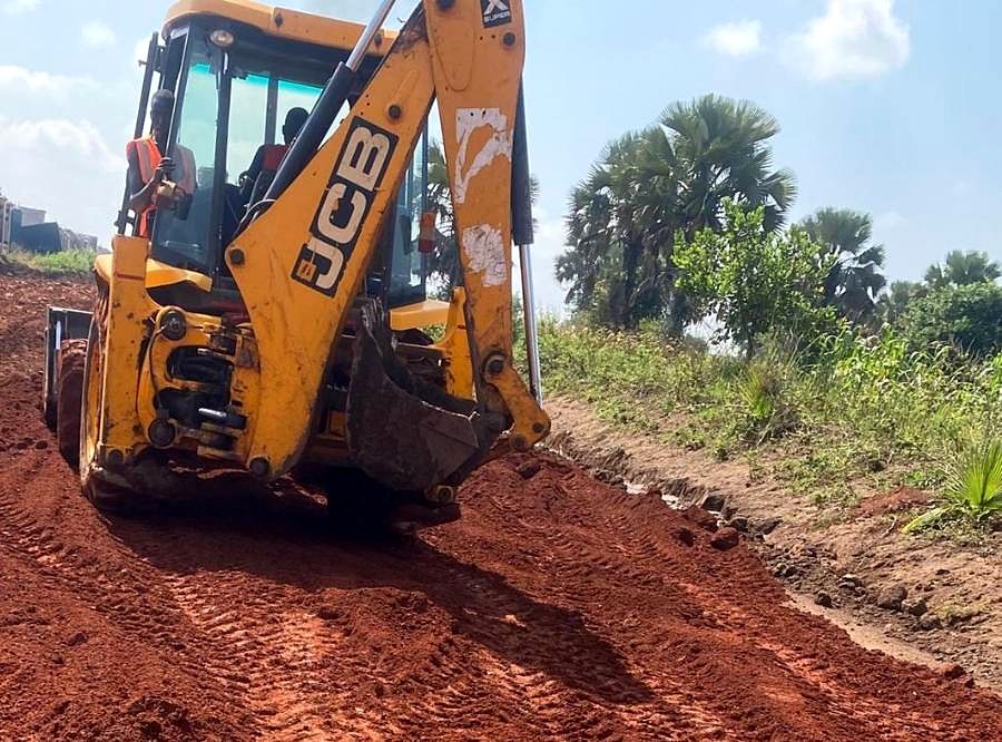 Backhoe loader grading a road