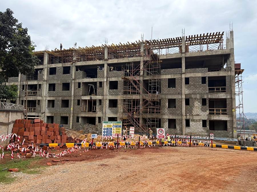 Multi-storey building under construction with concrete frame, block walling and scaffolding.